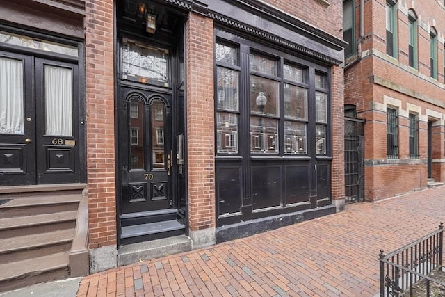 doorway to property featuring brick siding and french doors