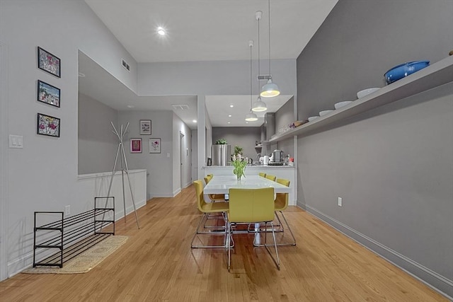 dining room featuring baseboards, visible vents, and light wood-type flooring