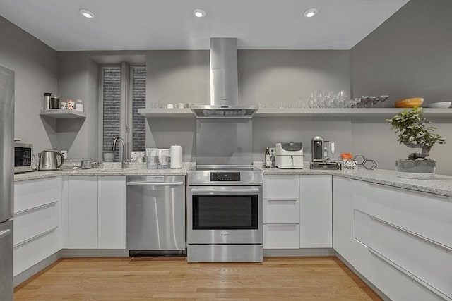 kitchen with white cabinets, stainless steel appliances, open shelves, and wall chimney exhaust hood