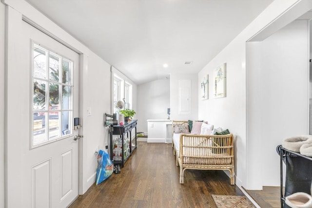 foyer entrance with lofted ceiling, baseboards, and wood finished floors