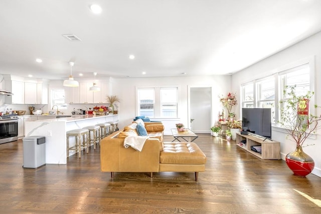 living area featuring dark wood-style floors, baseboards, visible vents, and recessed lighting