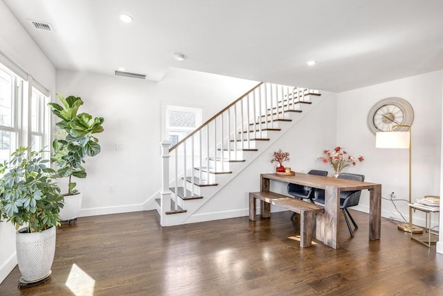 interior space with baseboards, visible vents, and wood finished floors