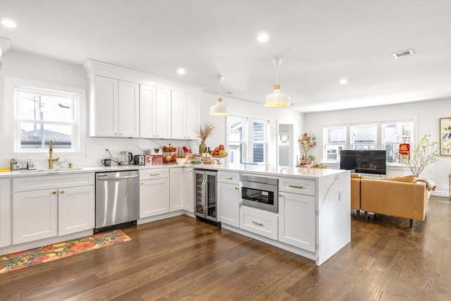 kitchen with dark wood-style floors, wine cooler, a peninsula, stainless steel dishwasher, and a sink