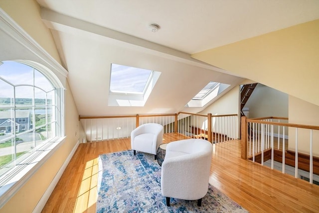 328 Central Ave, Scituate, MA 02050 - living area with plenty of natural light, wood finished floors, a skylight, vaulted ceiling, and an upstairs landing
