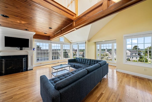 328 Central Ave, Scituate, MA 02050 - living room featuring light wood-style floors, a wooden ceiling with exposed beams, a glass covered fireplace, and high vaulted ceiling
