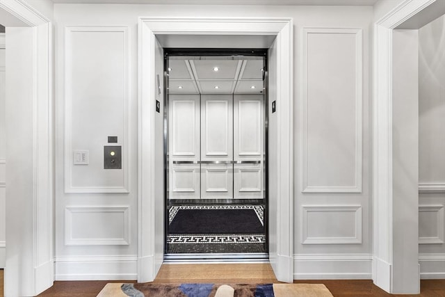 interior details featuring recessed lighting, elevator, baseboards, and wood finished floors