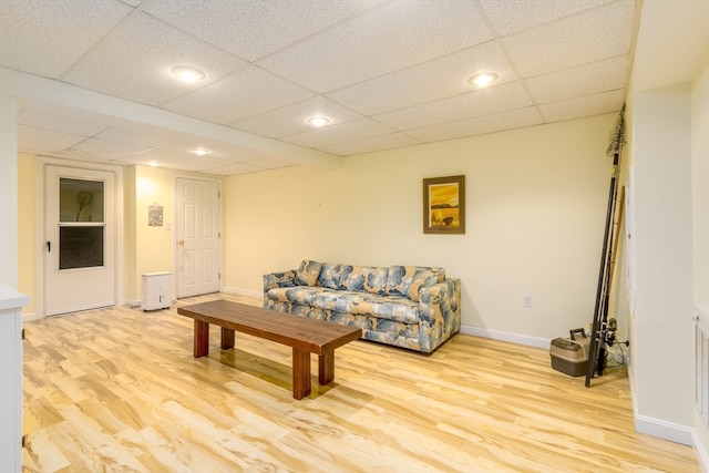 living room featuring a drop ceiling and light hardwood / wood-style floors