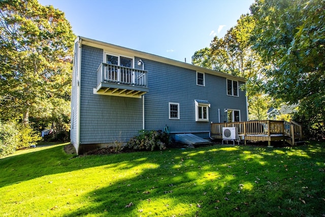 rear view of house with a yard, a deck, and a balcony