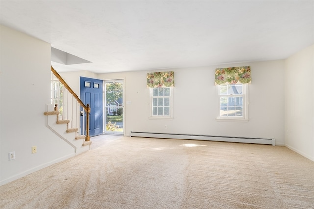 unfurnished living room featuring a healthy amount of sunlight, a baseboard radiator, and light colored carpet