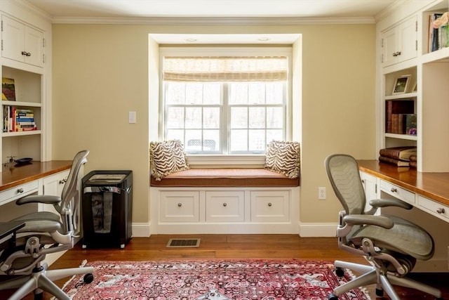 office with ornamental molding, dark hardwood / wood-style floors, and built in desk