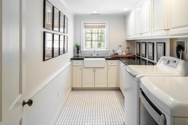 laundry area featuring cabinets, ornamental molding, sink, and washer and clothes dryer