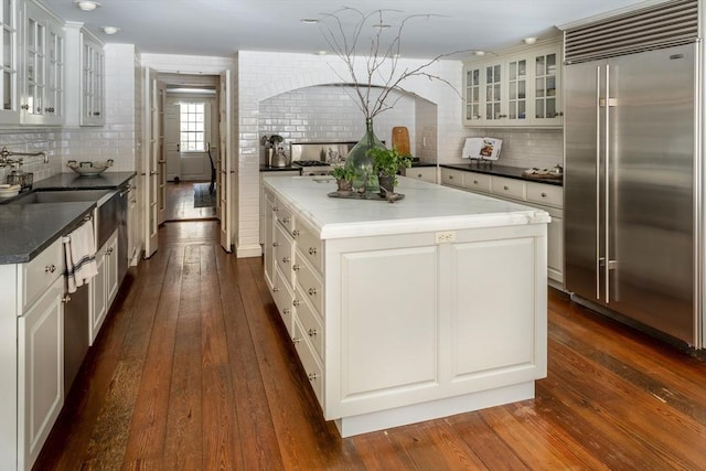 kitchen featuring white cabinetry, built in refrigerator, dark hardwood / wood-style floors, and a center island