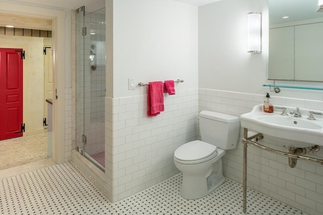 bathroom featuring sink, tile walls, walk in shower, toilet, and tile patterned floors