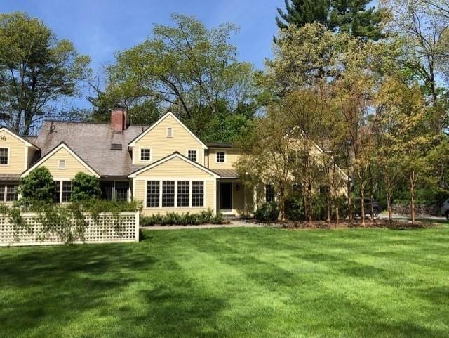 rear view of house featuring a yard