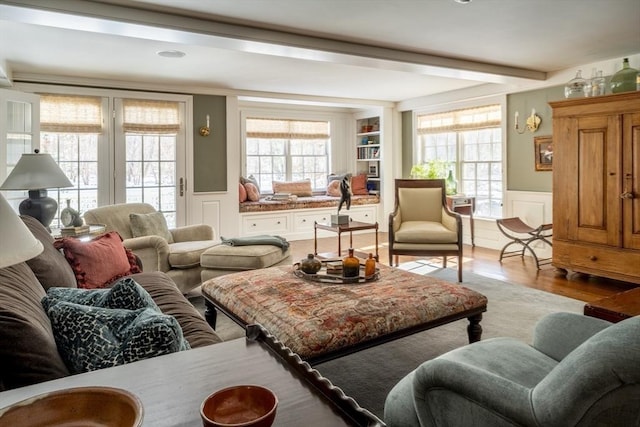 living room with beamed ceiling and light hardwood / wood-style flooring