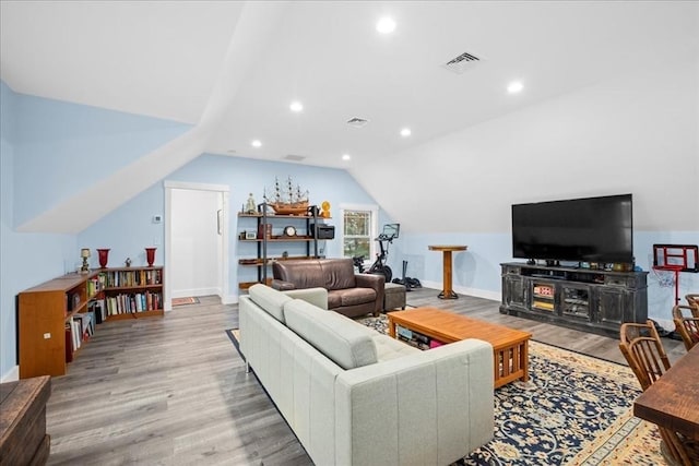 living room with hardwood / wood-style floors and vaulted ceiling