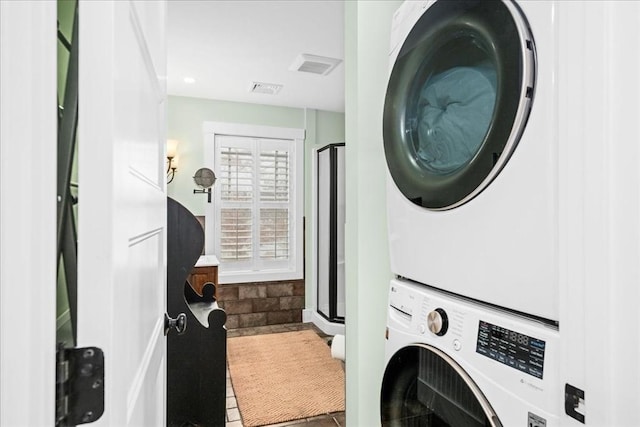 clothes washing area featuring tile patterned flooring and stacked washer / drying machine