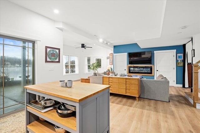 kitchen with ceiling fan, gray cabinets, light wood-type flooring, and light brown cabinetry