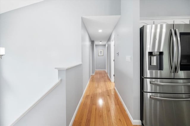 corridor with light wood-style flooring, baseboards, and recessed lighting