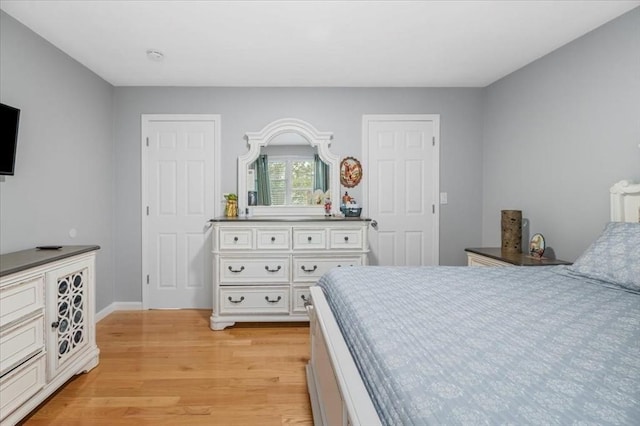 bedroom with light wood finished floors and baseboards