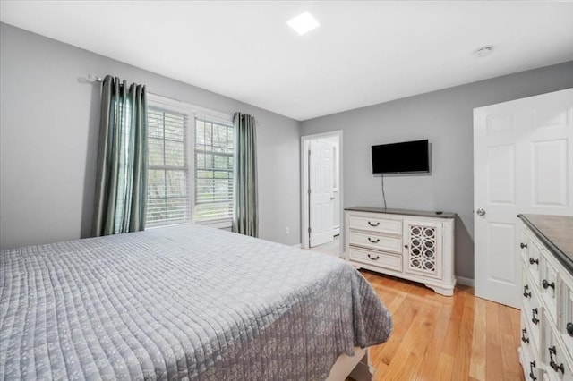 bedroom with light wood-style floors and baseboards