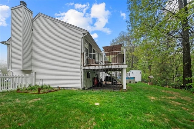 view of side of home with stairs, a wooden deck, and a chimney