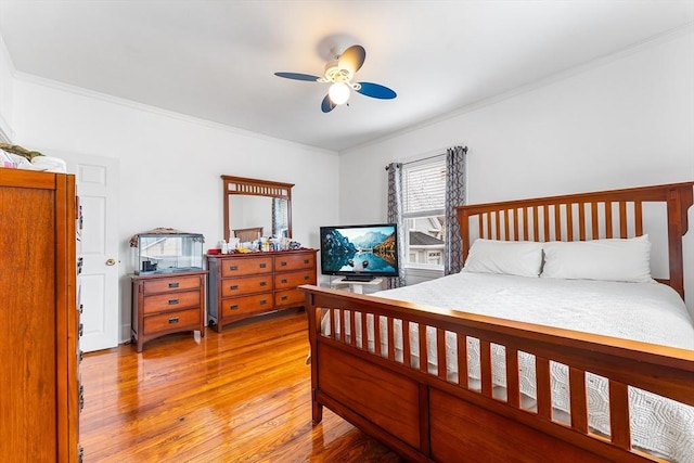 bedroom featuring light wood finished floors, ceiling fan, and ornamental molding