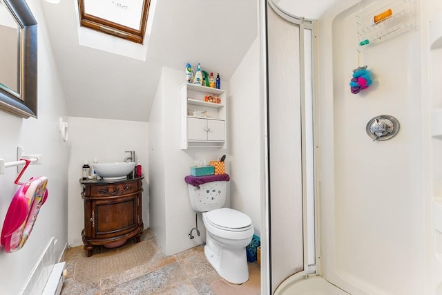 bathroom with toilet, walk in shower, vanity, and stone finish flooring