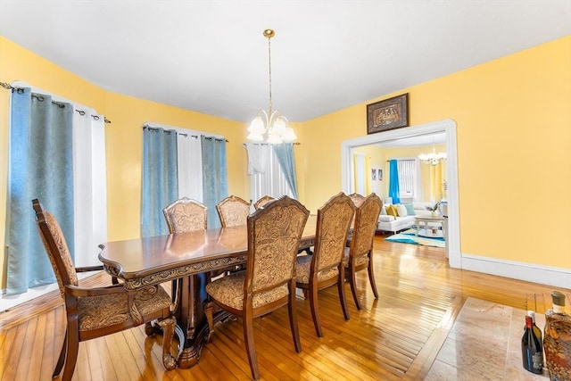 dining room featuring light wood finished floors and an inviting chandelier