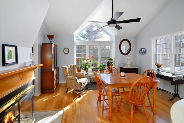 dining area with ceiling fan, vaulted ceiling, and light hardwood / wood-style floors