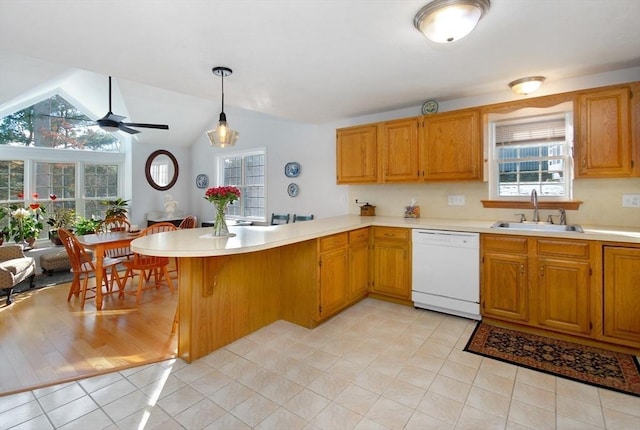 kitchen with pendant lighting, dishwasher, sink, kitchen peninsula, and light tile patterned flooring