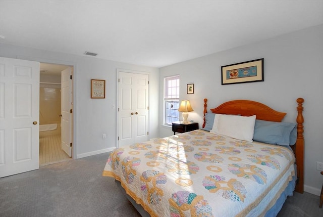 bedroom with carpet floors, a closet, and ensuite bath