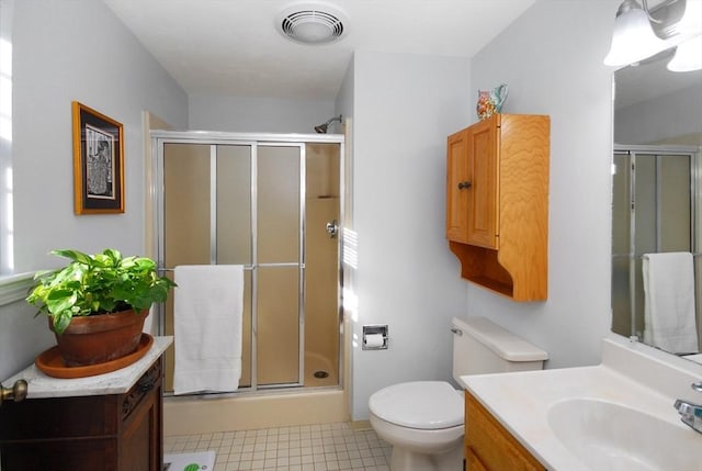 bathroom with a shower with door, toilet, tile patterned floors, and vanity