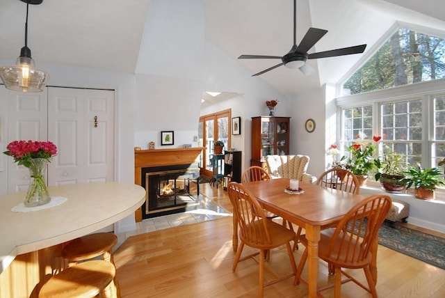 dining space with light hardwood / wood-style floors, high vaulted ceiling, and ceiling fan