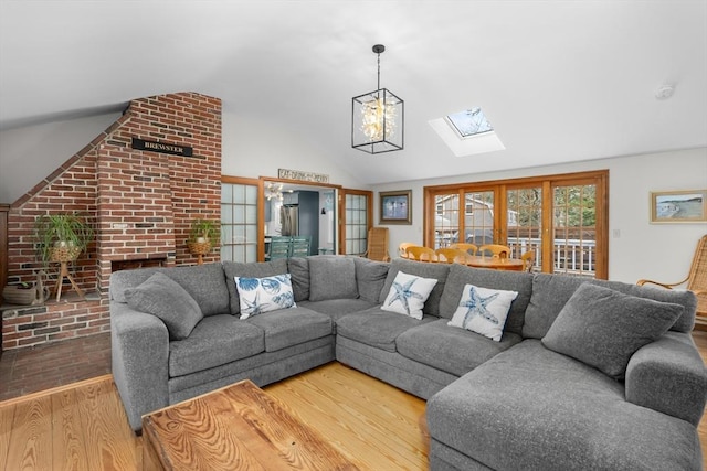 living area featuring vaulted ceiling with skylight and wood finished floors