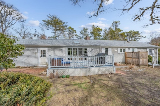 rear view of house with a chimney and a wooden deck