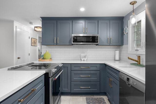 kitchen with tasteful backsplash, light tile patterned floors, light countertops, stainless steel appliances, and a sink