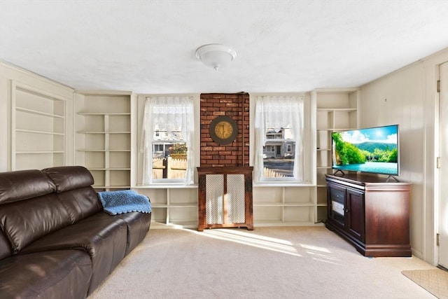 living area featuring built in shelves, a decorative wall, and light colored carpet