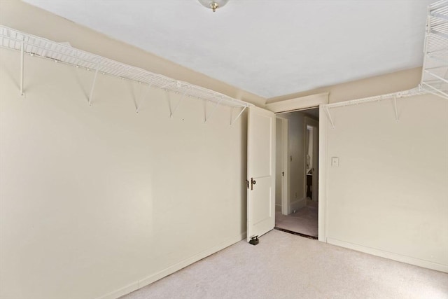 walk in closet featuring light carpet