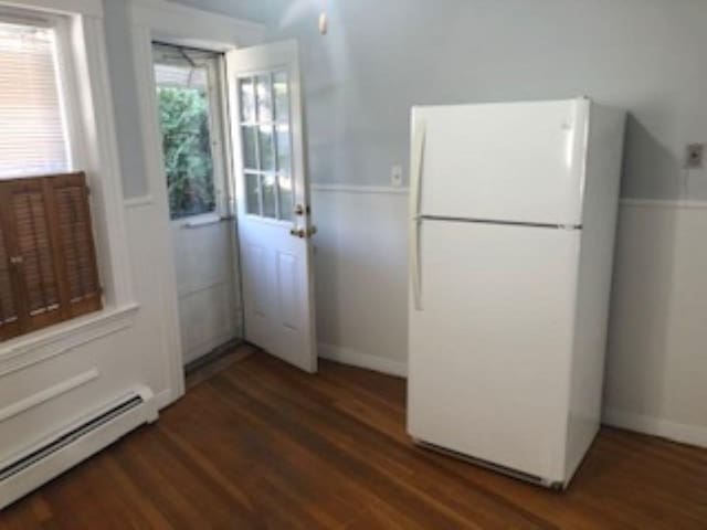 doorway with a baseboard radiator and wood finished floors