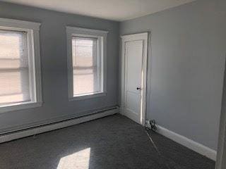 empty room with a healthy amount of sunlight, baseboards, and a baseboard radiator