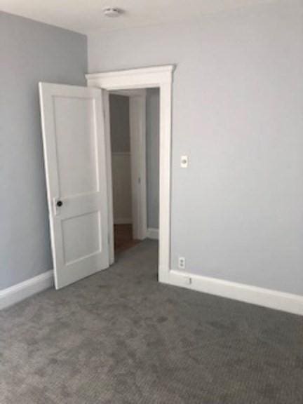 carpeted spare room with baseboards