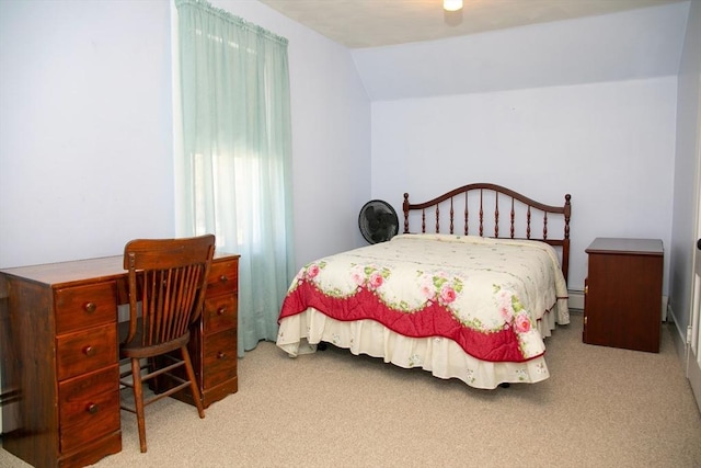 carpeted bedroom featuring vaulted ceiling and a baseboard radiator