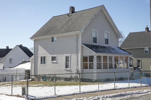 snow covered property featuring a sunroom