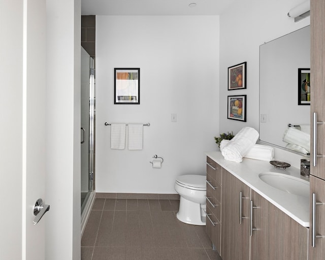 bathroom with tile patterned floors, vanity, toilet, and a shower with door