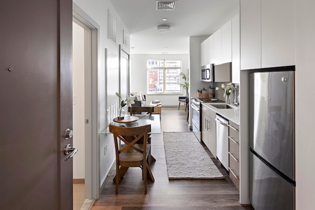 kitchen featuring white cabinets, hardwood / wood-style floors, stainless steel appliances, and sink