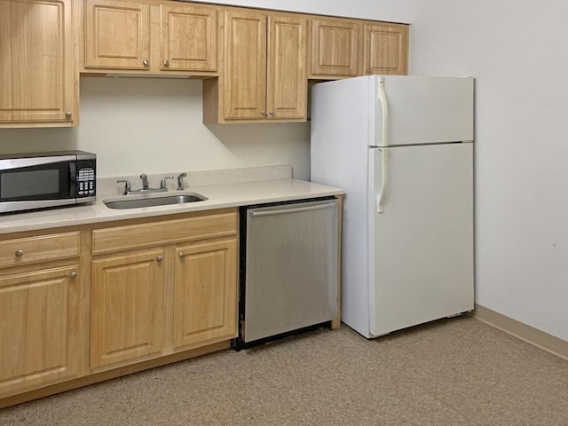 kitchen with a sink, appliances with stainless steel finishes, and light countertops