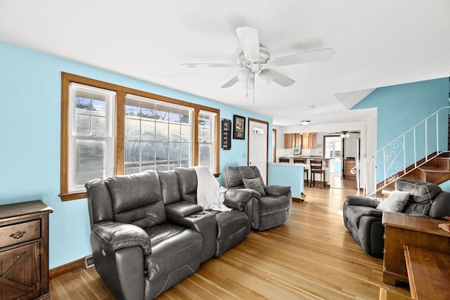 living room with ceiling fan and light hardwood / wood-style flooring