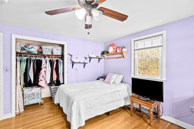 bedroom featuring ceiling fan, light hardwood / wood-style flooring, and a closet