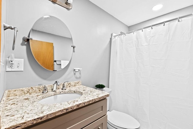 bathroom featuring a shower with curtain, vanity, and toilet